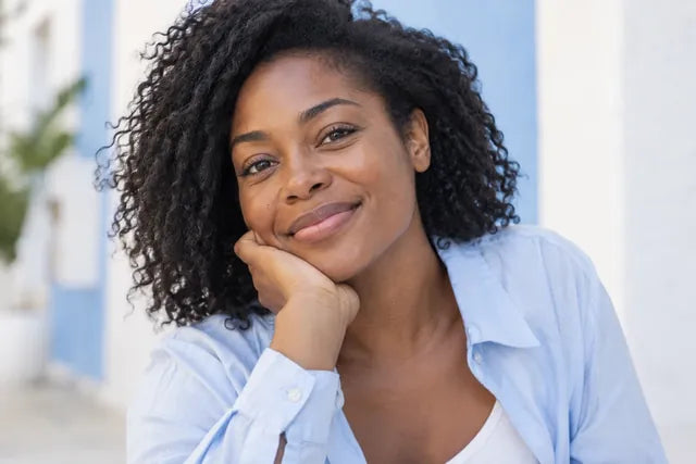 A woman smiles warmly in the shade