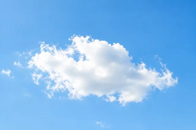 A clear blue sky with soft white clouds
