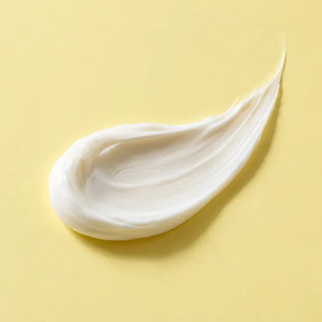 Close-up of a white cream texture on a yellow surface